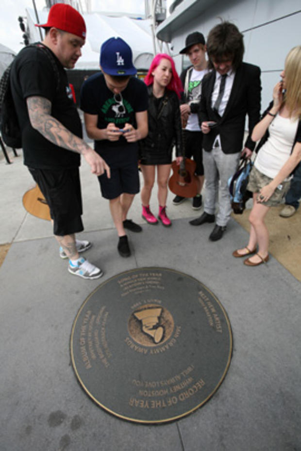 Fans take pictures of a bronze disk honoring Whitney Houston's Record of the Year and Album of the Year in LA 