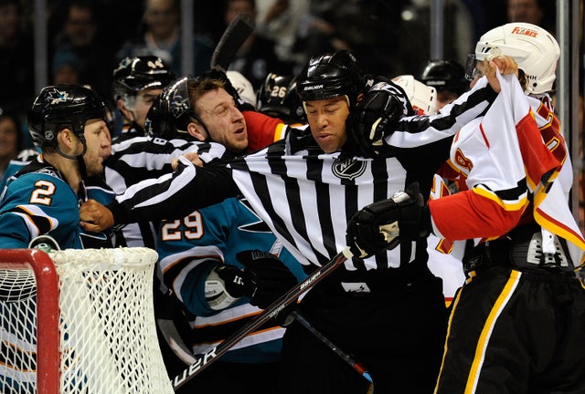 Linesman Jay Sharrers (57) breaks up a fight between Jim Vandermeer (2), Ryane Clowe (29) of the San Jose Sharks and Krys Kolanos (8) 
