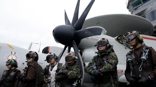 A crew stands by to receive an aircraft on the flight deck of the Nimitz-class aircraft carrier USS Abraham Lincoln during exercises in the Persian Gulf Feb. 13, 2012. The carrier sailed from the Persian Gulf through the Strait of Hormuz. 