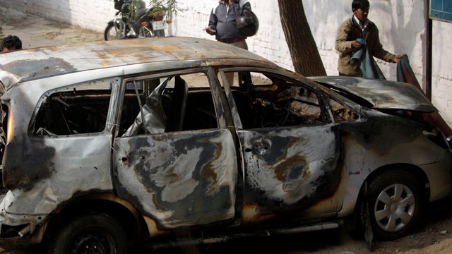 Police officers stand around an Israeli diplomat's car that was damaged in an explosion in New Delhi, India, Feb. 14, 2012. Indian investigators were searching for the motorcycle assailant who attached a bomb to an Israeli diplomatic car in the heart of N 