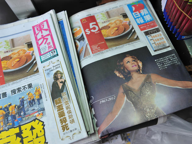 Two of the largest distributed Chinese language newspapers show a headline of the death of pop legend Whitney Houston in Hong Kong 
