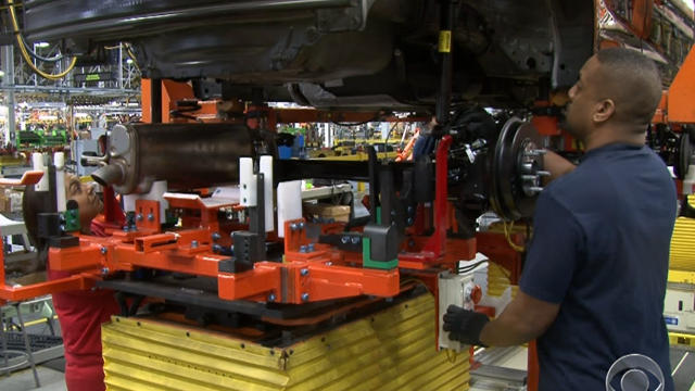 An auto worker assembles parts on the 2013 Dodge Dart 