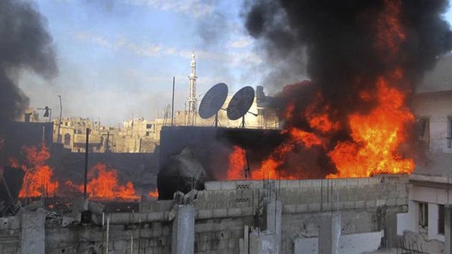 Flames rise from a house from Syrian government shelling, at Baba Amr neighborhood in Homs province 