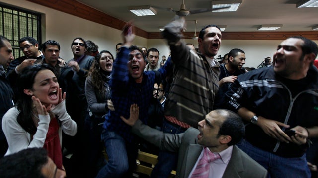 Egyptian protesters chant anti-military ruling slogans during a trial of employees of pro-democracy groups charged with using foreign funds to foment unrest in Cairo, Egypt, Feb. 26, 2012.  