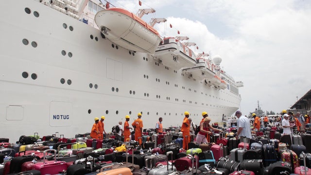 Passengers of the Costa Allegra cruise ship look for their baggage upon their arrival in the Seychelles 