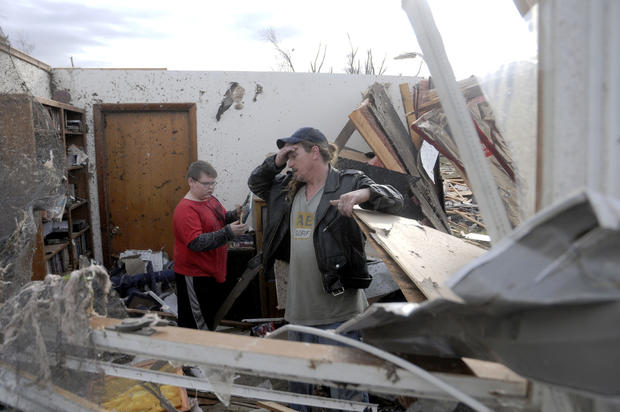 Gene Byrd pauses for a moment while he and his son Devyn Byrd, 14, look over some of the damage 