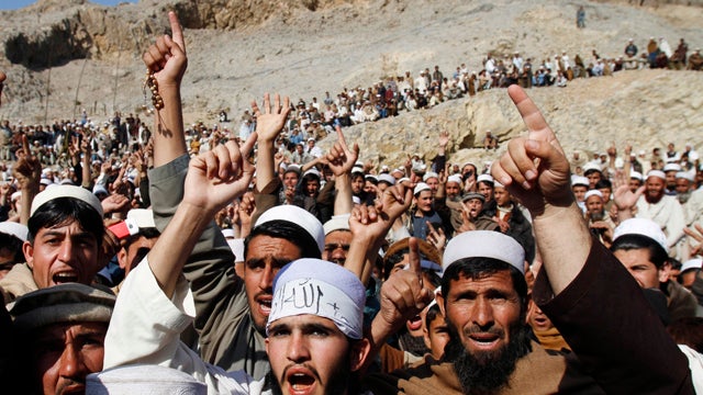 Afghan demonstrators show copies of Quran books allegedly set alight by US soldiers 