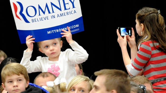 Bella Mow, 4, sits on her father Michael's shoulders and has her picture taken by Savannah Stewart, 9, as they wait for the arrival of Republican presidential candidate Mitt Romney March 1, 2012, in Idaho Falls, Idaho. 