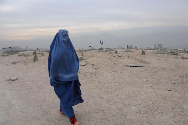 A burqa-clad Afghan woman walks in a cemetery Kabul on November 23, 2011. 