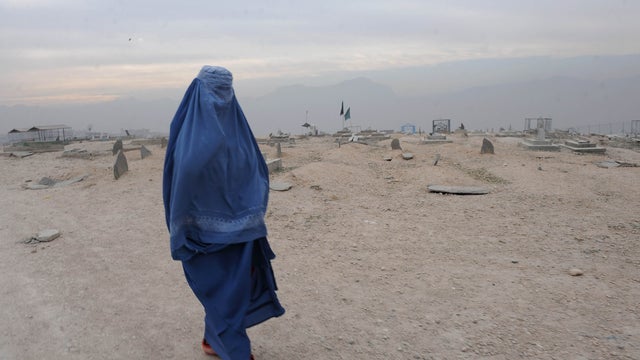 A burqa-clad Afghan woman walks in a cemetery Kabul on November 23, 2011. 
