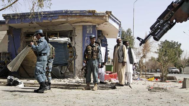 Afghan policemen are seen at the scene of a bomb explosion in Kandahar south of Kabul, Afghanistan, March 14, 2012.  