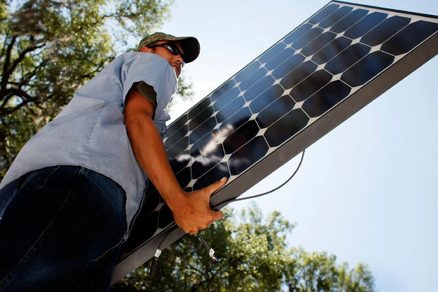 Worker installs a solar panel system on the roof of a home 