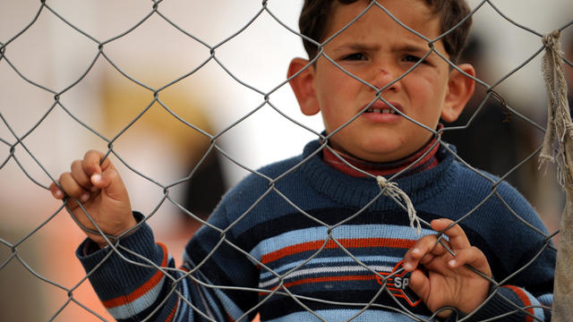 A Syrian refugee looks on from behind the fences of Boynuyogun Refugee Camp in Reyhanli, Turkey, March 13, 2012. 