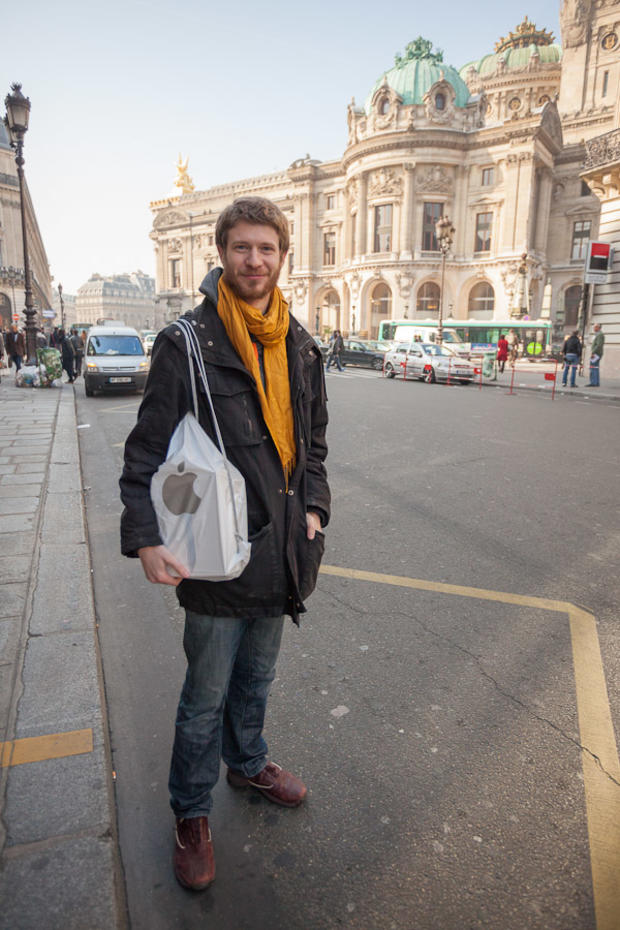 iOS programmer Joseph Pinkasfeld carries a new third-generation iPad out of the Apple store across the street from the Paris opera house, visible in the background. 