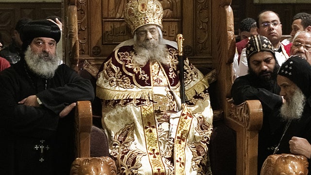 Egyptian Coptic priests gather around the body of Pope Shenuda III 