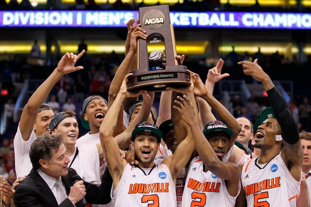 Rick Pitino, left, and his team hoist the game trophy as they celebrate their 72-68 win 