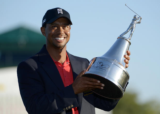 Tiger Woods hoists the championship trophy after winning the Arnold Palmer Invitational  