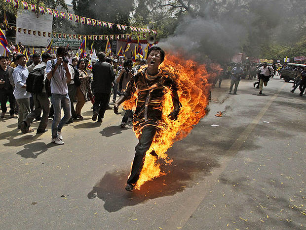 A Tibetan exile man, identified as Jampa Yeshi, runs engulfed in flames after self-immolating during a demonstration in New Delhi, India, March 26, 2012.  