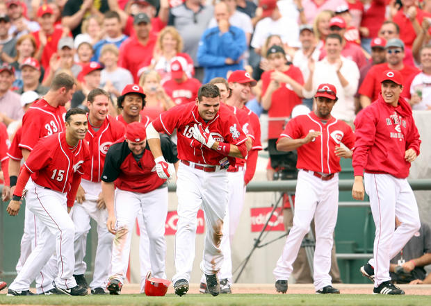 Joey Votto celebrates with teammates after hitting a single to bring in the game winning run 