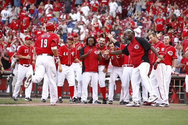 Joey Votto is greeted by teammates after hitting a game-winning solo home  