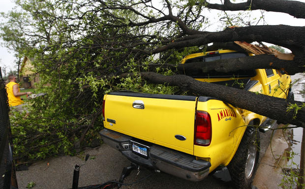 Harold Widner clears a fallen tree from his truck  