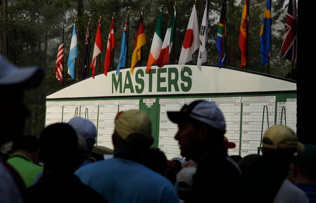 Spectators wait to get on the course to watch practice rounds after a delayed start because of fog  