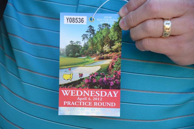 A patron displays his day pass for the final day of Practice Rounds 