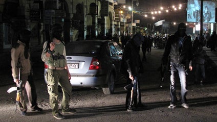 Free Syrian Army fighters guard a night protest in a neighborhood in Damascus 
