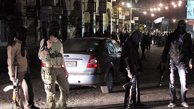 In this April 4, 2012 photo, Free Syrian Army fighters guard a night protest in a neighborhood in Damascus, Syria.  