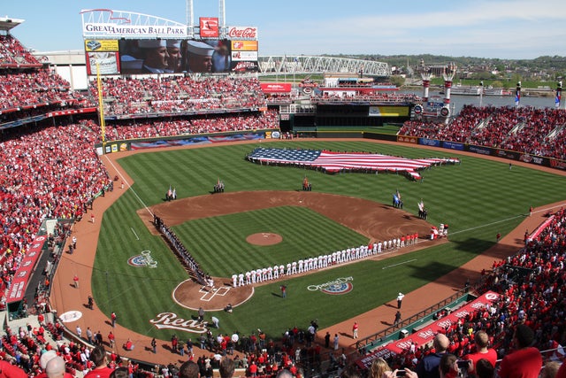 Miami Marlins and the Cincinnati Reds stand on the field during the National Anthem 