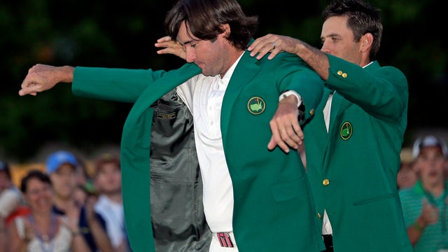 Charl Schwartzel, right, of South Africa, helps Bubba Watson put on the green jacket after winning the Masters golf tournament 