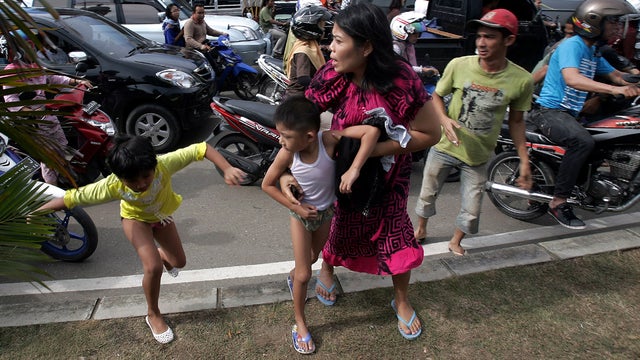 Acehnese people run shortly after a powerful earthquake hit the western coast of Sumatera in Banda Aceh, Indonesia, April 11, 2012. 