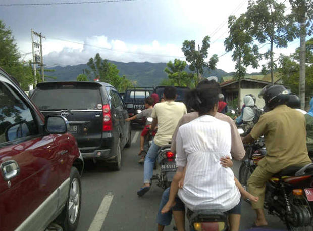 Residents on motorbikes and cars evacuate to higher ground after a strong earthquake was felt in Banda Aceh 