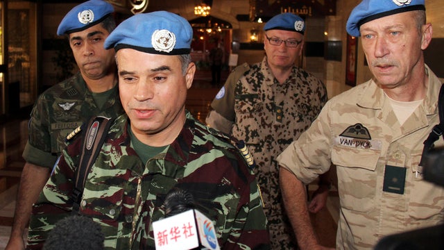Moroccan Col. Ahmed Himmiche, foreground, is flanked by other U.N. observers as he talks to journalists before leaving the Sheraton Hotel in Damascus, Syria, April 16, 2012. 