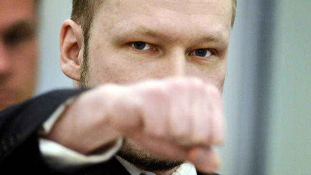 Right-wing extremist Anders Behring Breivik, who killed 77 people in twin attacks in Norway last year, makes a far-right salute as he enters an Oslo district courtroom at the opening of his trial April 16, 2012. 