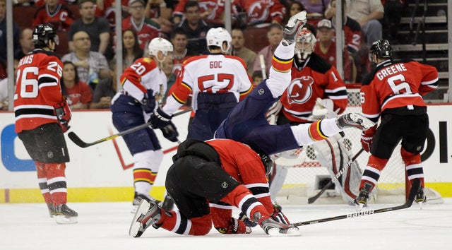 Dmitry Kulikov flips over Dainius Zubrus 