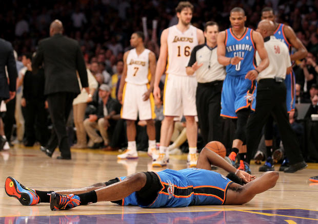 James Harden lies on the floor after being hit by Metta World Peace 