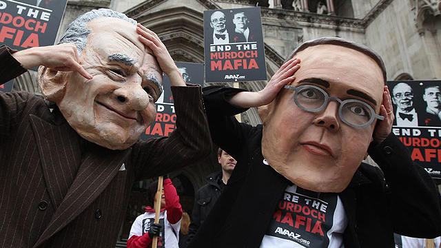 Protesters from the campaign group 'Avaaz' demonstrate outside the High Court with large James and Rupert Murdoch masks as former News International chairman James Murdoch gives evidence to The Leveson Inquiry on April 24, 2012 in London, England.  