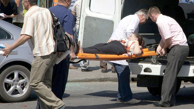 People assist an injured person after an explosion in Dnipropetrovsk, Ukraine, April 27, 2012. 