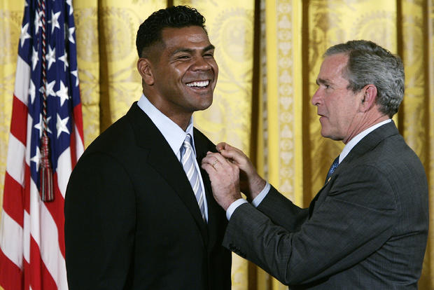 George W. Bush presents an award to recipient Miami Dolphins linebacker Junior Seau  