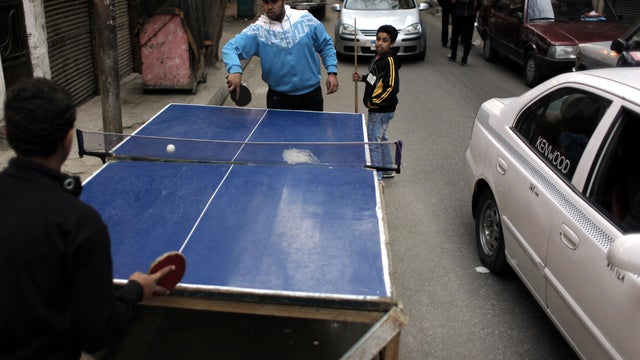 Two Egyptian youths play table tennis while they occupy part of a street in Cairo March 25, 2012. 