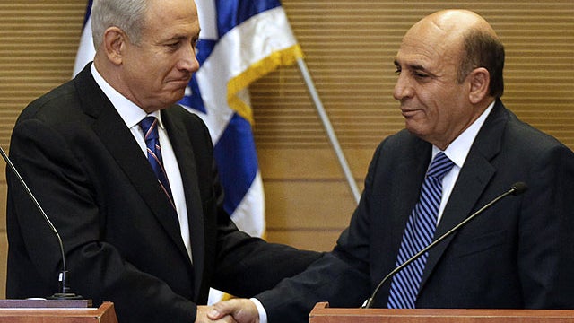 Israeli Prime Minister Benjamin Netanyahu, left, shakes hands with Kadima party leader Shaul Mofaz during a joint press conference at the Knesset, Israel's parliament, in Jerusalem on May 8, 2012.  