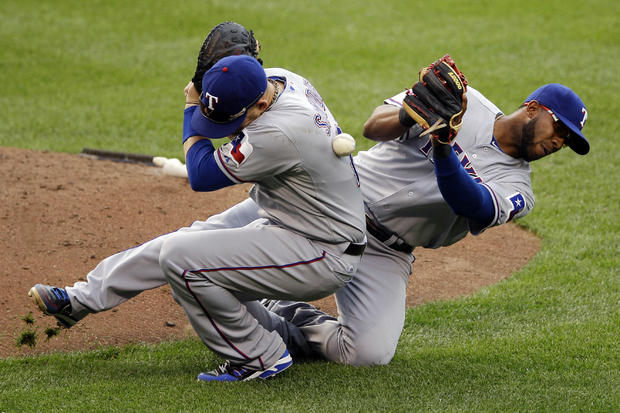 Brandon Snyder, left, and shortstop Elvis Andrus collide as they drop a pop fly  