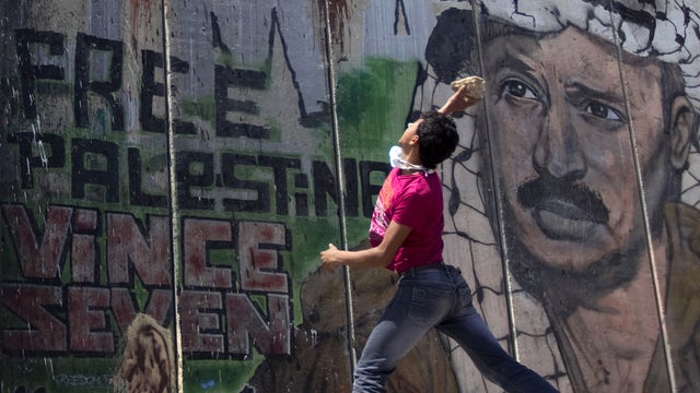 Palestinian protester hurls stone at Israeli troops 