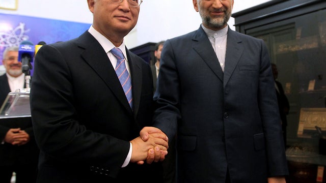 International Atomic Energy Agency chief Yukiya Amano, left, shakes hands with Iran's chief nuclear negotiator Saeed Jalili in Tehran, Iran, May 21, 2012. 