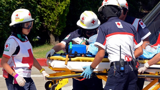 Red Cross emergency responders carry away an unidentified 5-year-old boy on a stretcher after being flown via helicopter to a medical facility in Mexico City May 24, 2012. 