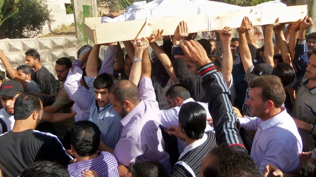 Anti-Syrian regime mourners chant slogans May 26, 2012, in the Kfar Suseh area of Damascus, Syria, as they carry the body of soldier Khaled Shurbajy, who was shot by Syrian security forces in Dir el Zour, Syria, after disobeying orders to fire on anti-Ass 
