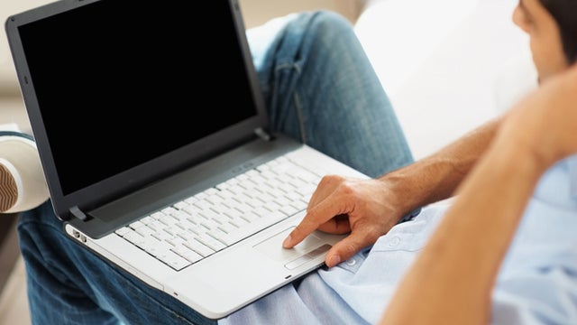 Closeup of guy working on a laptop indoor 