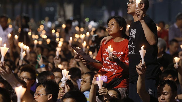 People hold lit candles during a candlelight vigil at Hong Kong's Victoria Park Monday, June 4, 2012 to mark the 23rd anniversary of the Chinese military crackdown on the pro-democracy movement in Beijing.  