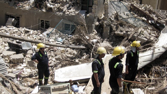 Firefighters and rescuers search for victims at the site of a bomb attack in the central Bab al-Muadham area in Baghdad, Iraq, Monday, June 4, 2012.  